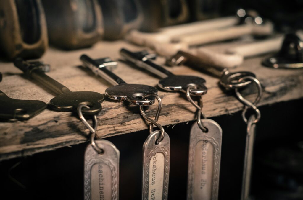 A row of keys on the table with key rings dangling over the edge
